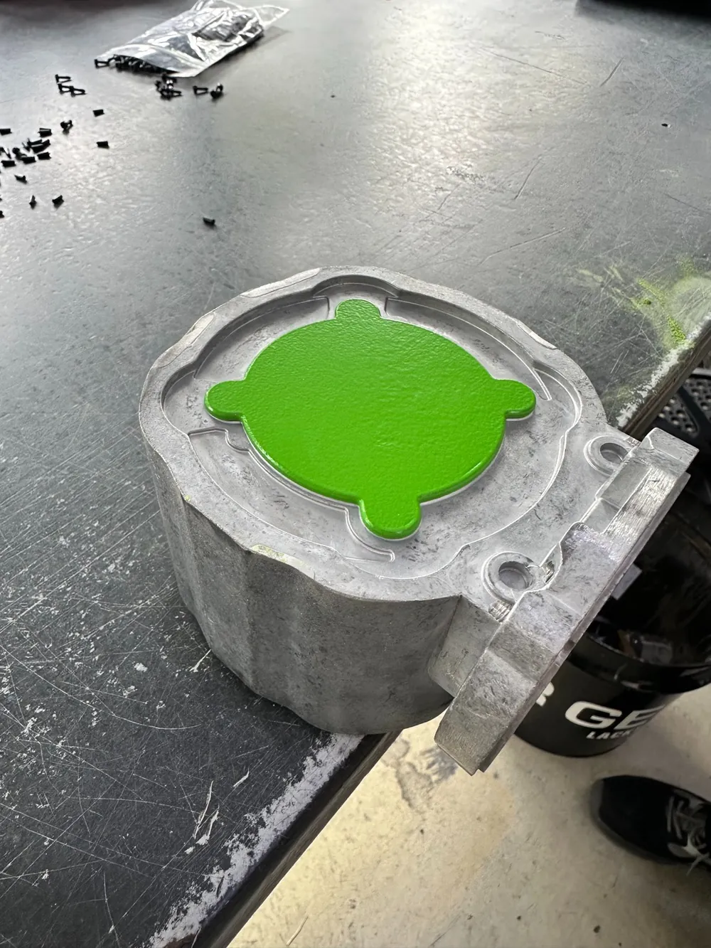 3D-gedruckte Lackier-Maskierung mit Belüftungs-Zinnen und Halte-Lasche neben dem sauber maskierten, pulverbeschichteten Gehäuse
